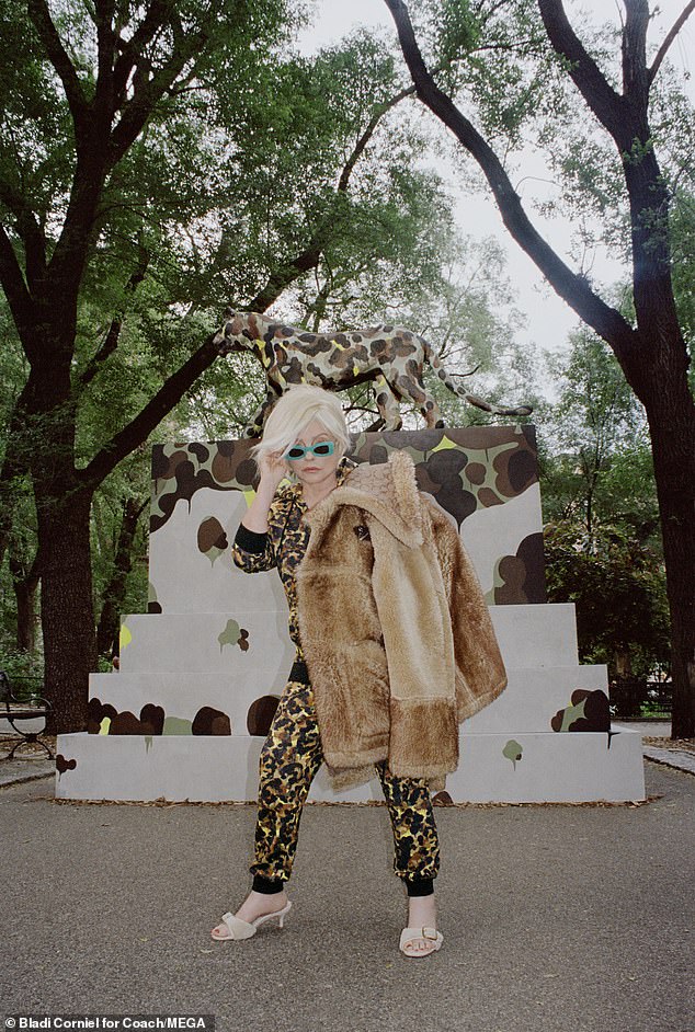 Imagínese esto: Debbie Harry de Blondie demostró que todavía tenía su estilo de estrella de rock mientras posaba con un abrigo de piel y tonos verde azulado funky para una nueva Campaña de Entrenadores el miércoles.
