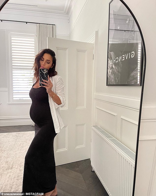 ¡Está brillando!  La estrella de Bachelor, Snezana Wood, de 41 años, mostró su creciente panza con un vestido negro mientras posaba para una selfie en el espejo el lunes.