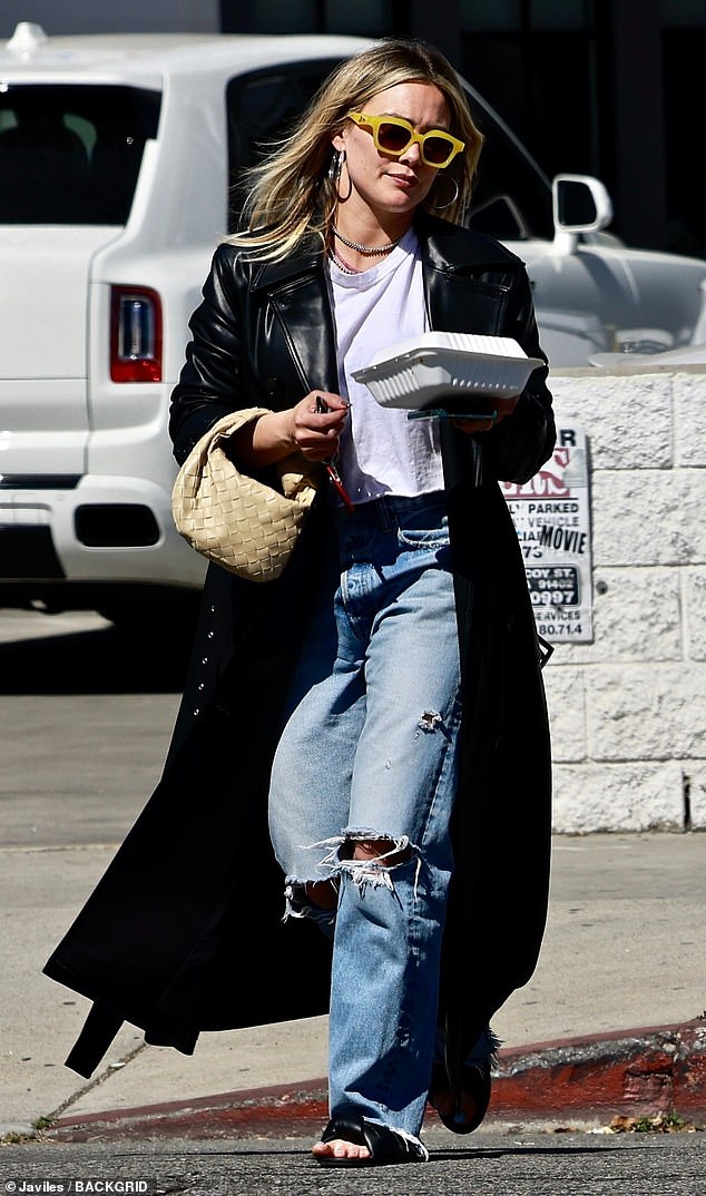 Relajante: Hilary Duff, de 34 años, parecía haber elegido su propio estilo grunge con jeans rasgados, una camiseta recortada y un abrigo negro de espuma para una cita para almorzar con un amigo el viernes.