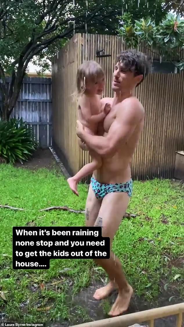 Húmedo: NSW ha sido golpeado con lluvias récord.  Pero Matty 'J' Johnson (en la foto) estaba aprovechando al máximo el mal tiempo el lunes, jugando con su hija en su patio trasero lluvioso.