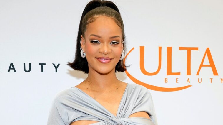 Rihanna aturde con un top corto plateado y una falda larga de tiro bajo