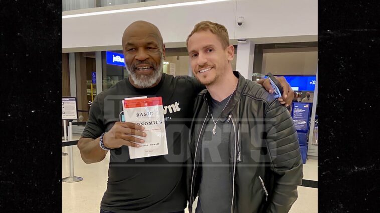 Mike Tyson posa para una foto con un fan minutos después de la golpiza del avión