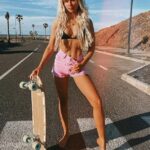 Impresionante: Lucie Donlan mostró sus abdominales tonificados en una parte superior de bikini negra y pantalones cortos de color rosa mientras tomaba el sol mientras patinaba descalza en California el lunes.