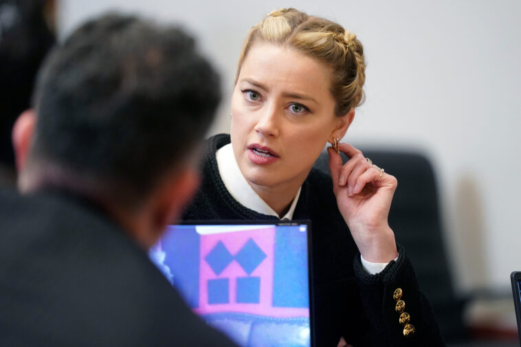 Actor Amber Heard speaks with a member of her legal team in the courtroom at the Fairfax County Circuit Courthouse in Fairfax, Va., Thursday, May 19, 2022. Actor Johnny Depp sued his ex-wife Amber Heard for libel in Fairfax County Circuit Court after she wrote an op-ed piece in The Washington Post in 2018 referring to herself as a "public figure representing domestic abuse." (Shawn Thew/Pool Photo via AP)