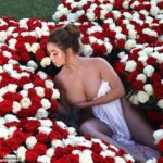 Flower power: Demi Rose hizo alarde de sus increíbles curvas en una sesión de fotos de flores picantes el martes que la vio rodeada de ramos románticos, aparentemente sin nada más que una sábana.