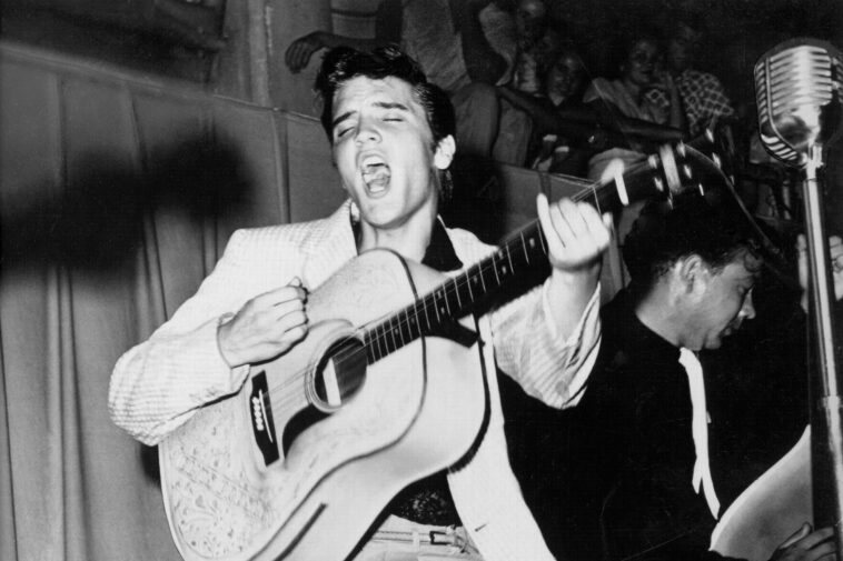 TAMPA, FL - JULY 31: Rock and roll singer Elvis Presley performs on stage with his brand new Martin D-28 acoustic guitar on July 31, 1955 at Fort Homer Hesterly Armory in Tampa, Florida. (Photo by Michael Ochs Archives/Getty Images)