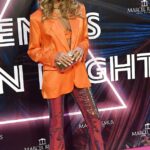 Glam: Elle Macpherson se destacó entre la multitud con un blazer naranja brillante y pantalones deslumbrantes cuando asistió a la Remus Neon Night en Mallorca el viernes.