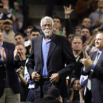 FILE - In this Feb. 15, 2012, file photo, former Boston Celtic Bill Russell, middle, receives a standing ovation after being introduced prior to the Celtics' NBA basketball game against the Detroit Pistons in Boston. Paul Pierce joins the basketball Hall of Fame, and Bill Russell goes in as a coach when the shrine holds its induction ceremony for the class of 2021 on Friday, Sept. 10, 2021. (AP Photo/Elise Amendola, File)