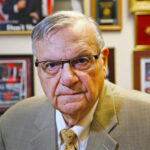 FILE - In this Aug. 26, 2019, file photo, former Maricopa County Sheriff Joe Arpaio poses for a portrait at his private office in Fountain Hills, Arizona. Taxpayers in metro Phoenix are paying one of the last major legal bills for his headline-grabbing tactics that inspired thousands of lawsuits during his six terms in office. Maricopa County paid $100 million in attorney fees, settlements and other costs in Arpaio-era lawsuits. Separately, taxpayers have shelled out another $178 million in a 2007 racial profiling case stemming from Arpaio's traffic patrols that targeted immigrants, though much of spending occurred during his successor's watch. (AP Photo/Ross D. Franklin, File)