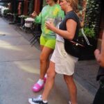 Iggy Azalea, de 32 años, sin maquillaje (a la izquierda, con una amiga) cubrió sus famosas curvas con una sudadera verde holgada cuando salió al Soho, en la ciudad de Nueva York, el sábado.