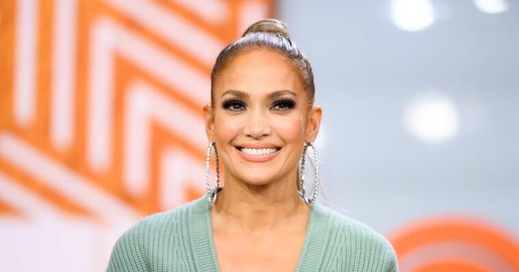 J Lo usa un vestido de suéter escotado con una abertura a la altura del muslo en Instagram Live