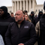 WASHINGTON, DC - JANUARY 05: Flanked by personal security, Alex Jones leaves after speaking at a Stop the Steal rally in front of the Supreme Court on Tuesday, Jan. 5, 2021 in Washington, DC.  (Kent Nishimura / Los Angeles Times via Getty Images)