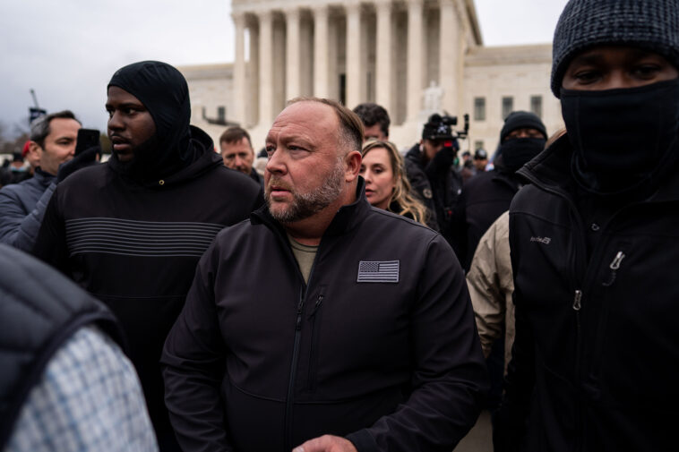 WASHINGTON, DC - JANUARY 05: Flanked by personal security, Alex Jones leaves after speaking at a Stop the Steal rally in front of the Supreme Court on Tuesday, Jan. 5, 2021 in Washington, DC.  (Kent Nishimura / Los Angeles Times via Getty Images)