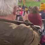¡Ciertamente es un fan!  Un entusiasta del fútbol fue captado mirando fotos de Jane Bunn en su iPhone en la AFL en Melbourne el fin de semana.