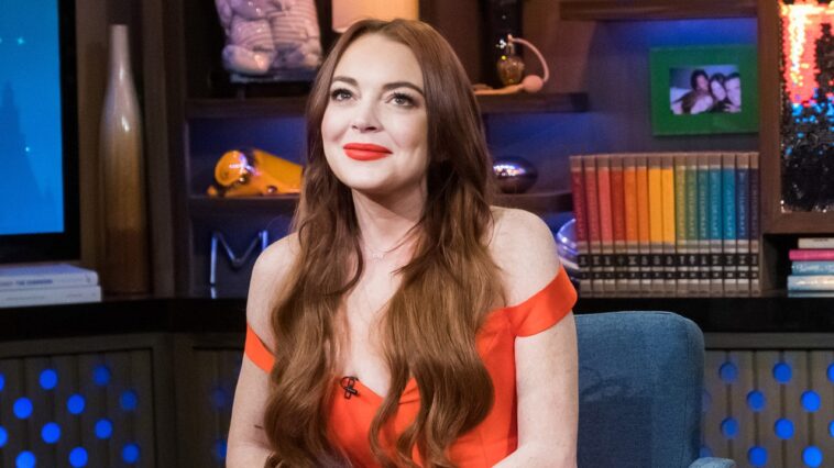 El mono rojo de Lindsay Lohan está dando flores de Pascua en el póster oficial de su nueva película navideña