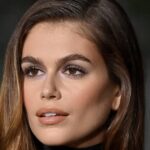 Las uñas de baño de leche de Kaia Gerber brillan contra su blusa transparente de cuello alto