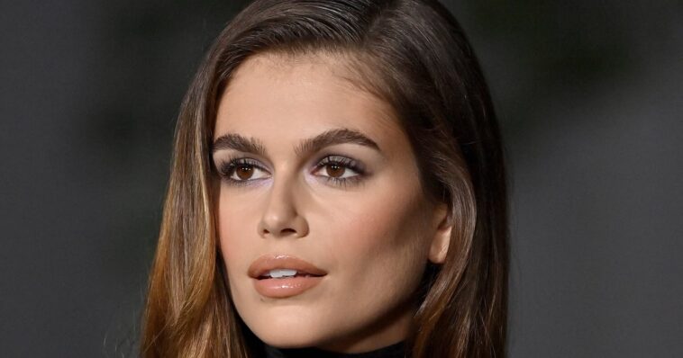 Las uñas de baño de leche de Kaia Gerber brillan contra su blusa transparente de cuello alto