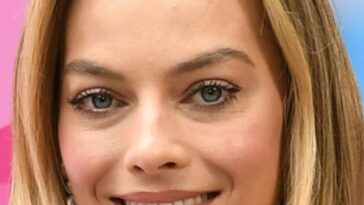 las uñas de espacio negativo de margot robbie combinan con el recorte de su vestido